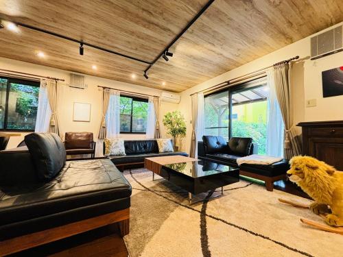a living room with couches and a dog on the floor at Sakai Garden and Villa in Sakai