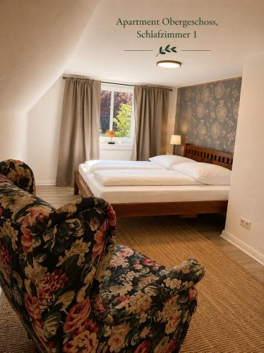 a bedroom with a bed and two chairs at Villa Deli in Wischhafen