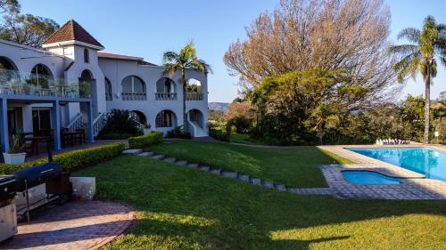 an exterior view of a house with a swimming pool at Mountain View International Hotel - Eswatini in Mbabane