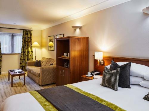 a hotel room with a bed and a couch at Mercure Barnsley Tankersley Manor Hotel in Barnsley