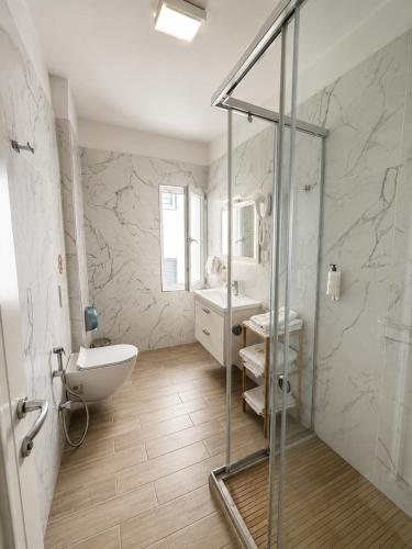 a bathroom with a glass shower and a sink at ART Hotel Tirana in Tirana