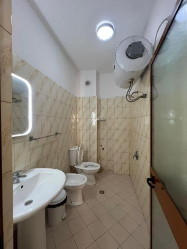 a bathroom with a sink and a toilet and a shower at Rigandi in Durrës
