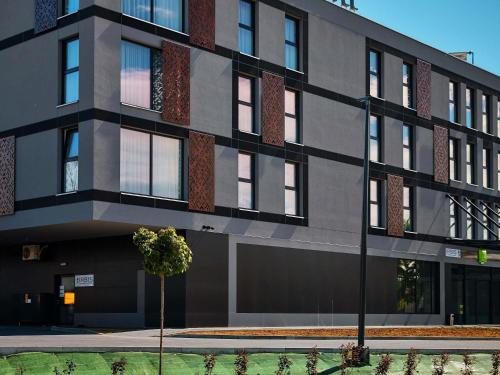 a building with a tree in front of it at ibis Styles Nowy Targ in Nowy Targ