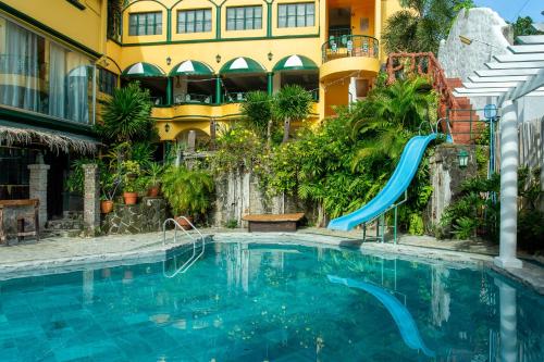 a swimming pool with a slide in front of a building at Yahweh's Spring Retreat and Resort in Calamba