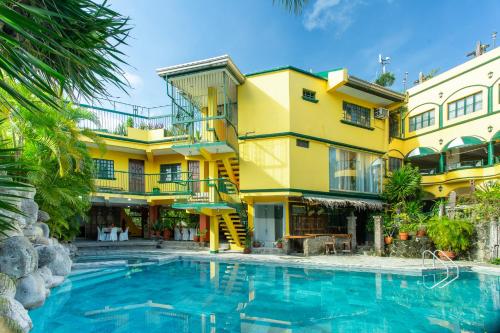 a hotel with a swimming pool in front of a building at Yahweh's Spring Retreat and Resort in Calamba