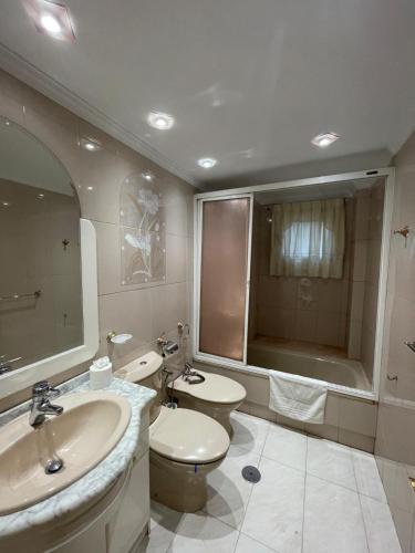 a bathroom with a sink and a toilet and a tub at Casa Diego in Muñón Fondero