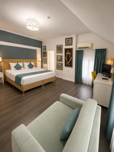 a hotel room with a bed and a couch at ART Hotel Tirana in Tirana