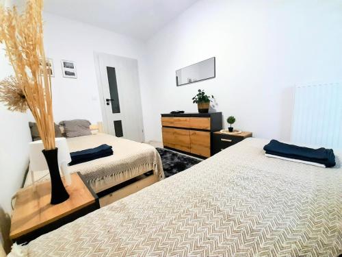 a bedroom with two twin beds and a dresser at Apartament Amelia in Zamość