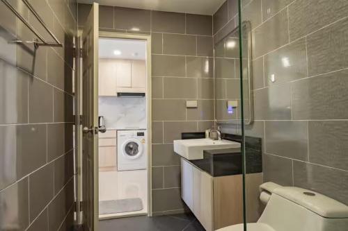 a bathroom with a toilet and a sink and a washing machine at The Terraza Condotel in Nathon Bay