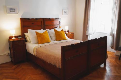 a bedroom with a large bed with yellow pillows at TT Apartmani - Historic Center Pula in Pula
