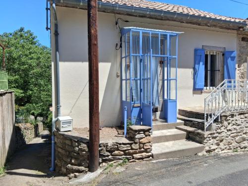 a small white house with blue doors and stairs at Les volets bleus in Prémian