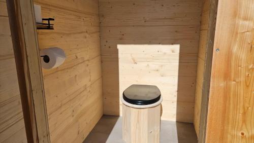 a small bathroom with a toilet in a wooden room at Glamping Šumava in Hartmanice