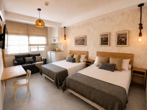 a hotel room with two beds and a couch at Hostal Casa Miguel Marbella in Marbella