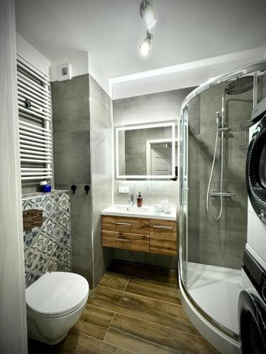 a bathroom with a toilet and a sink and a shower at InGalaxy Green Apartment in Szczecin