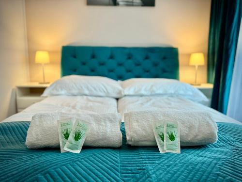 a bed with towels and pillows on top of it at InGalaxy Green Apartment in Szczecin