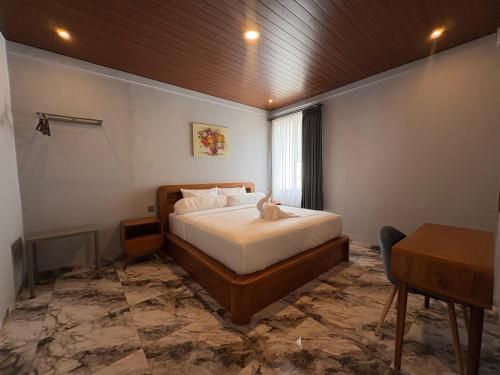 a bedroom with a bed and a table in it at Tera Bali Villa 3 Bedugul in Bedugul