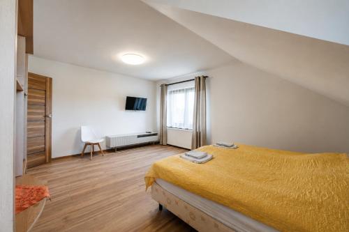 a bedroom with a bed with a yellow bedspread at Apartament pod gruszą in Legbąd