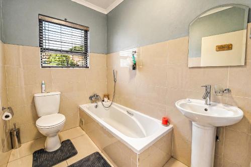 a bathroom with a toilet and a sink and a tub at Swallows Nest Haven in Boksburg