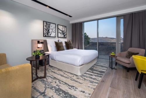 a hotel room with a bed and a large window at Citadines Abha in Abha