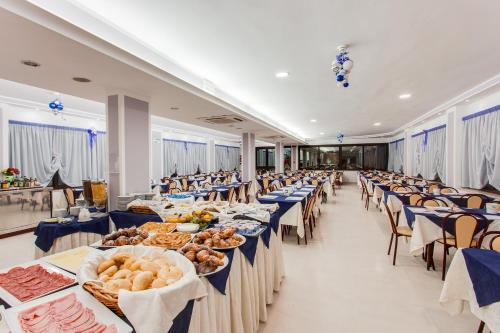 チェゼナーティコにあるHotel Delle Nazioniの青いテーブルクロスが並ぶ大宴会場