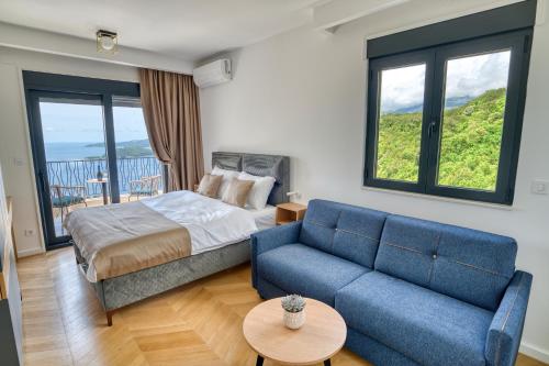 a bedroom with a bed and a blue couch at Quercus Villa 2 in Blizikuće