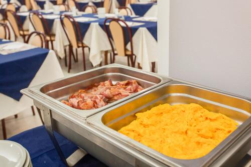 een dienblad met eten op een tafel met wat eten bij Hotel Delle Nazioni in Cesenatico