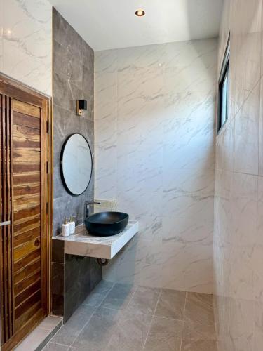 a bathroom with a sink and a mirror at An An Pool Villa in Nong Prue
