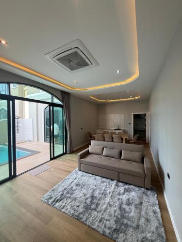 a living room with a couch and a table at An An Pool Villa in Nong Prue