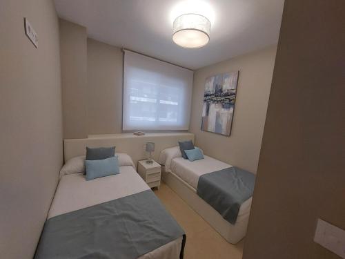a small room with two beds and a window at Luc61 - Vistas al mar in La Estación