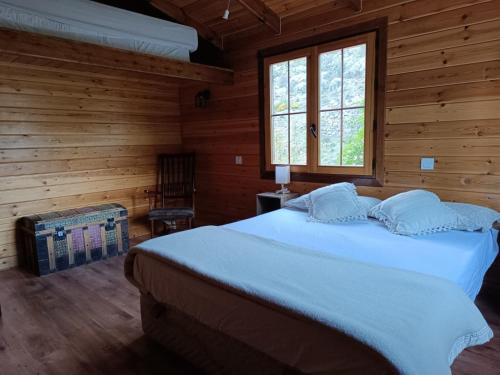 a bedroom with a large bed in a wooden room at Casa de la Hoz in Calomarde