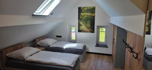 two beds in a room with two windows at KaMi Self check-in 24 h in Głogówek
