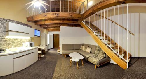 a living room with a staircase and a couch at AHA Jasná Apartmány in Liptovský Mikuláš