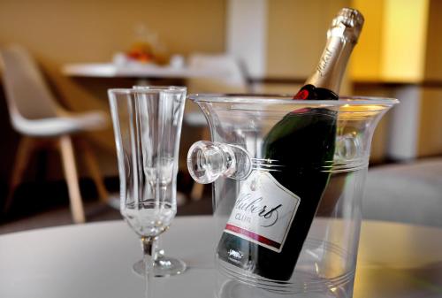a bottle of wine in a container next to a glass at AHA Jasná Apartmány in Liptovský Mikuláš