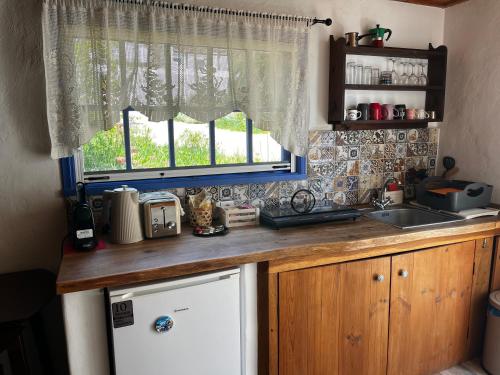 a kitchen with a sink and a window and a dishwasher at Sandra Studio in Lachania