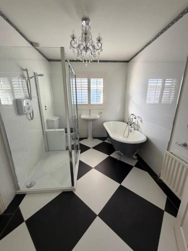 a bathroom with a black and white checkered floor at Tullyally House in Castle Cary