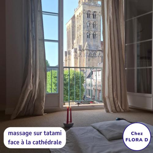 a bedroom with a bed and a large window at Chez FLORA D - Lisieux hypercentre - in Lisieux