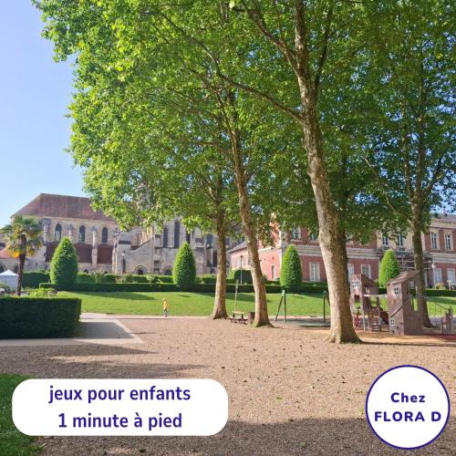 a park with trees in front of a building at Chez FLORA D - Lisieux hypercentre - in Lisieux