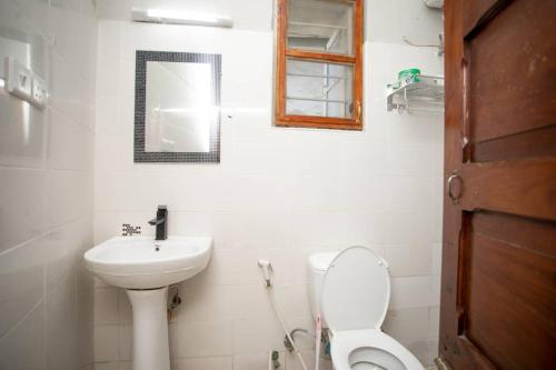 a bathroom with a sink and a toilet and a mirror at Daf House in Zanzibar City