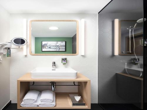 a bathroom with a sink and a mirror at Mercure Warszawa Ursus Station in Warsaw