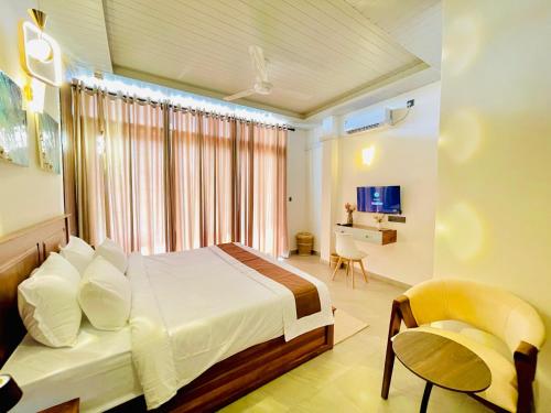 a bedroom with a bed and a chair and a desk at Secret Gem in Arugam Bay