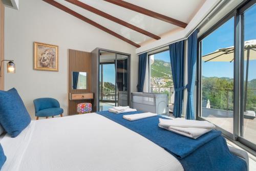 a bedroom with a large bed and large windows at Villa Ekinoks in Kalkan