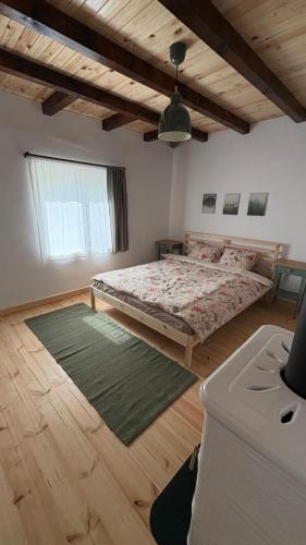 a bedroom with a bed and a large window at Casa dintre munti in Bozioru