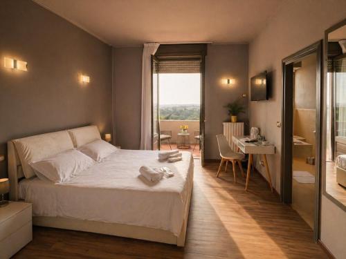 a bedroom with a bed and a desk and a window at Aia del vento in Cisternino