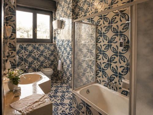 a bathroom with a sink and a tub and a toilet at Aia del vento in Cisternino