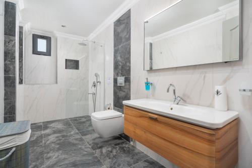 a bathroom with a sink and a toilet and a mirror at Villa Ekinoks in Kalkan