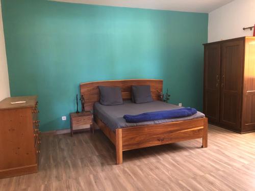a bedroom with a bed and a blue wall at Chez Roseline in Ndangane