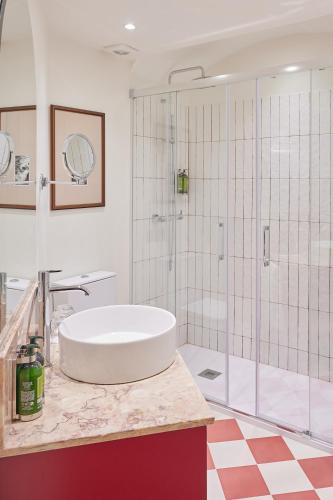 a white bathroom with a tub and a shower at Hotel Fortaleza do Guincho Relais & Châteaux in Cascais