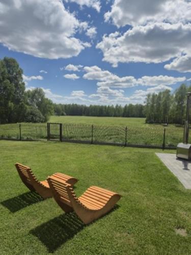 two chairs sitting on the grass in a field at Brzozowa Polanka in Lipowiec Stary