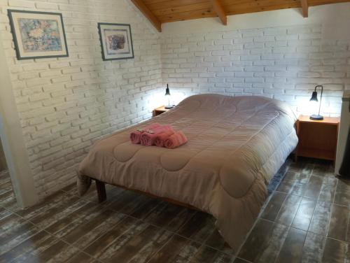 a bedroom with a bed with two pink towels on it at Hosteria Atelier in Tigre