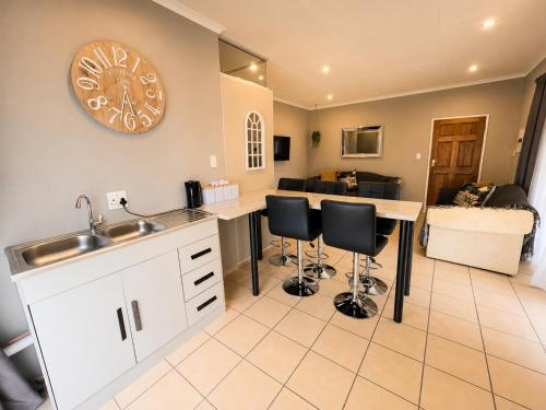 a kitchen with a sink and a counter with stools at Zhantique Guest House 2- Unit 6 in Boksburg